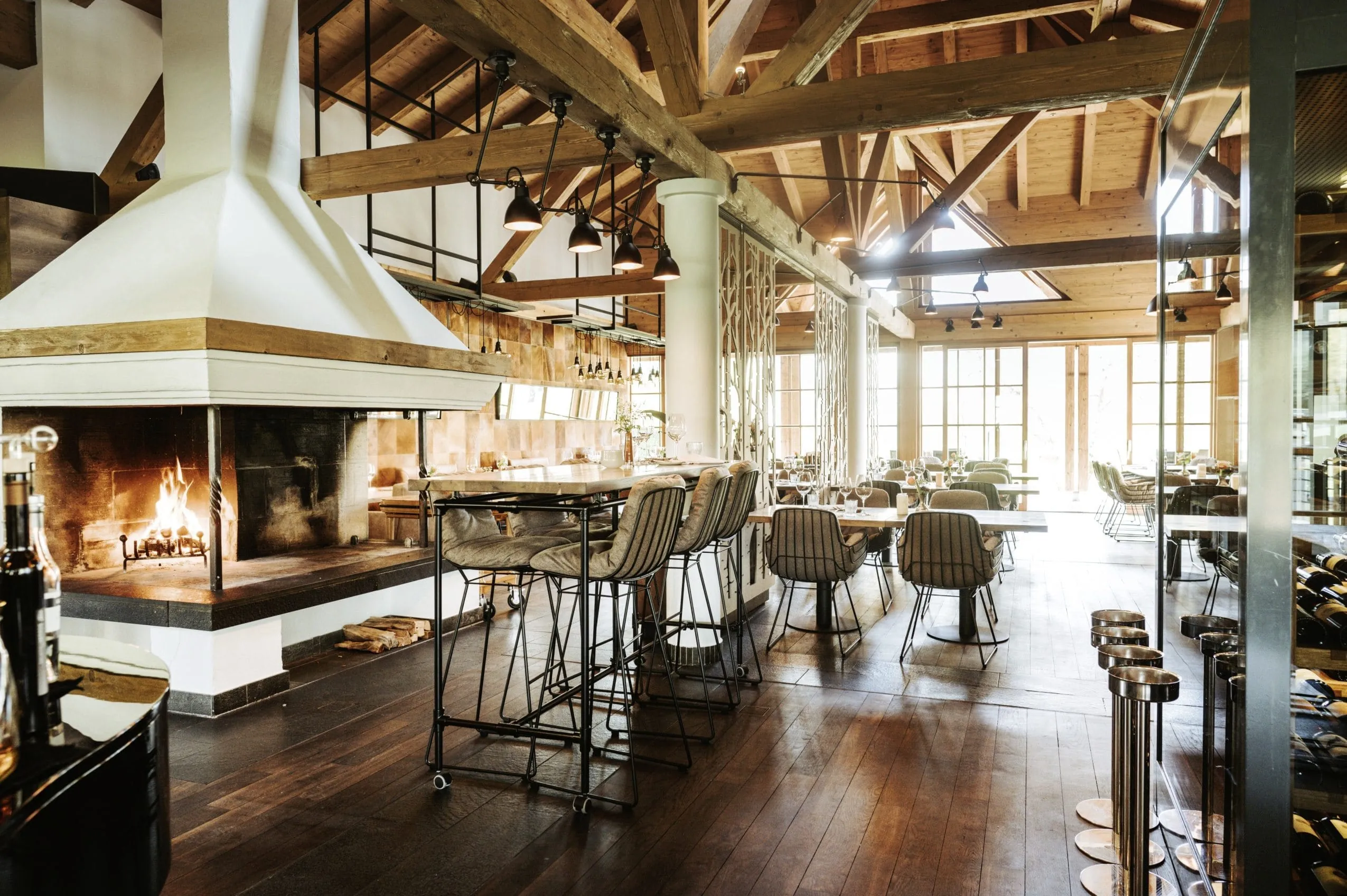 Das Restaurant im Schlosshotel Kitzbühel, ehemals A-ROSA mit Kamin und hohen Holzdecken.