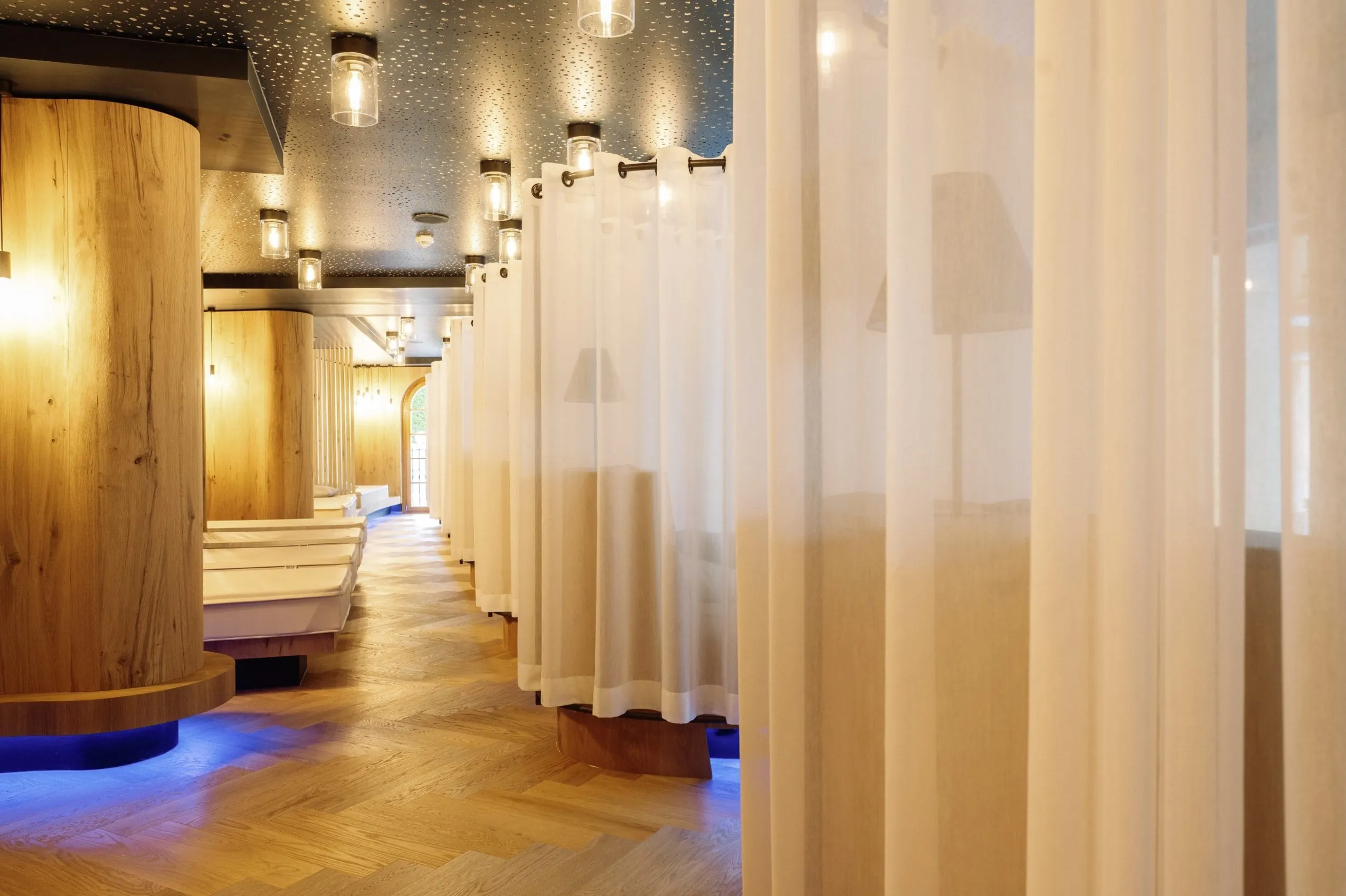 Ruhebereich mit Gardinen und warmem Deckenlicht im Schlosshotel Kitzbühel.