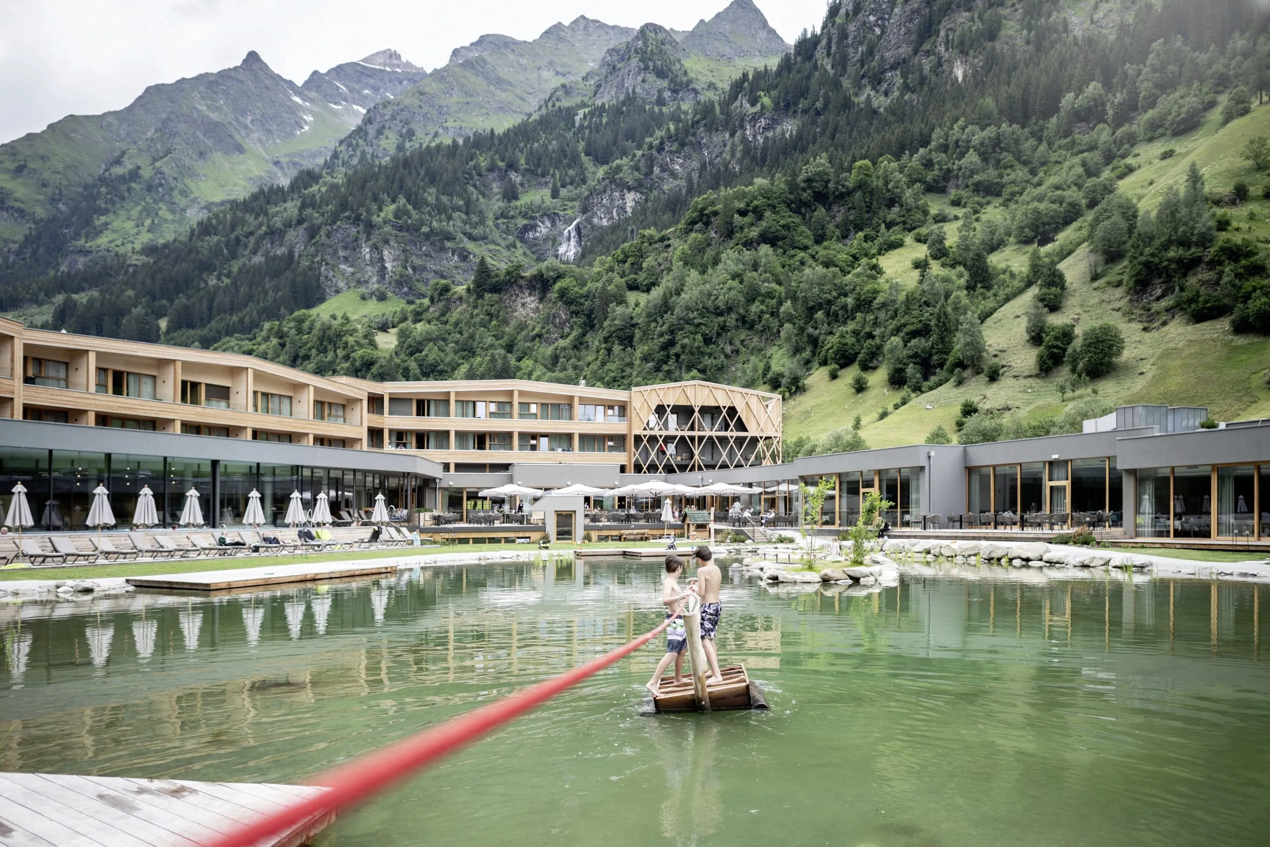 Kinder beim Bootfahren im Feuerstein Nature Family Resort, umgeben von Bergen und Berghängen.