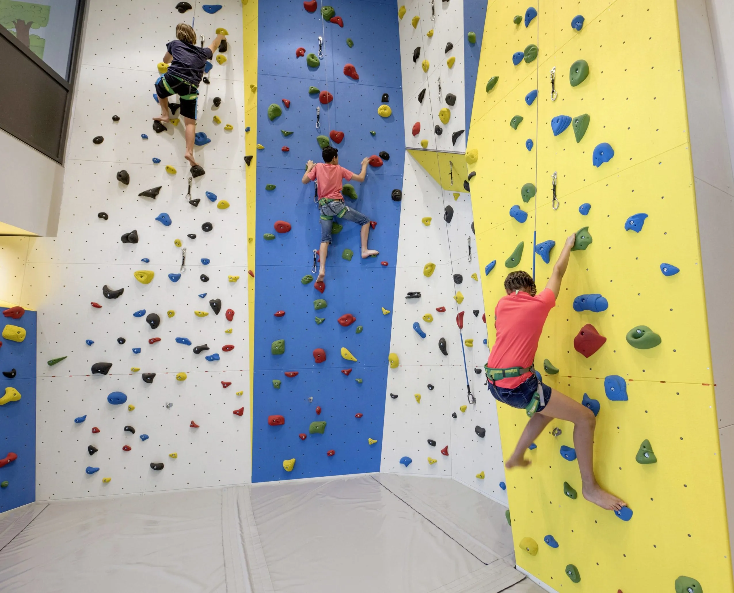 Jugendliche beim Klettern auf der Kletterwand im Hotel Quellenhof Luxury Resort Passeier in St.Martin.