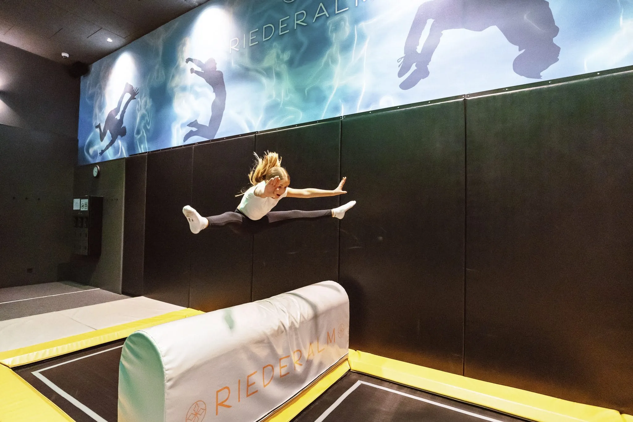 Eine Mädchen springt in der Trampolinhalle im Good Life Resort Riederalm.