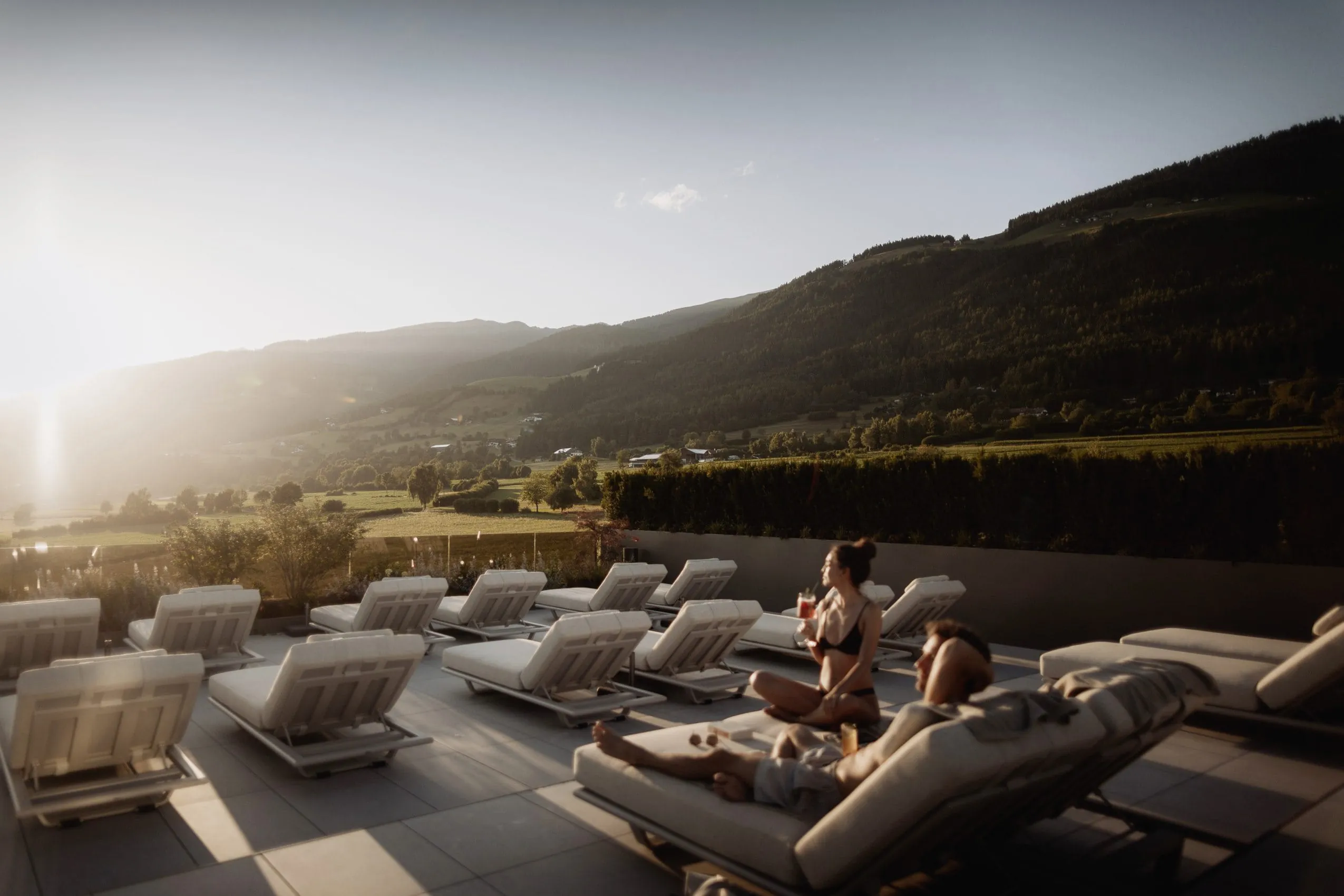 Ein Paar sitzt auf der Dachterrasse des Hotel Solvie und genießt den Sonnenuntergang.