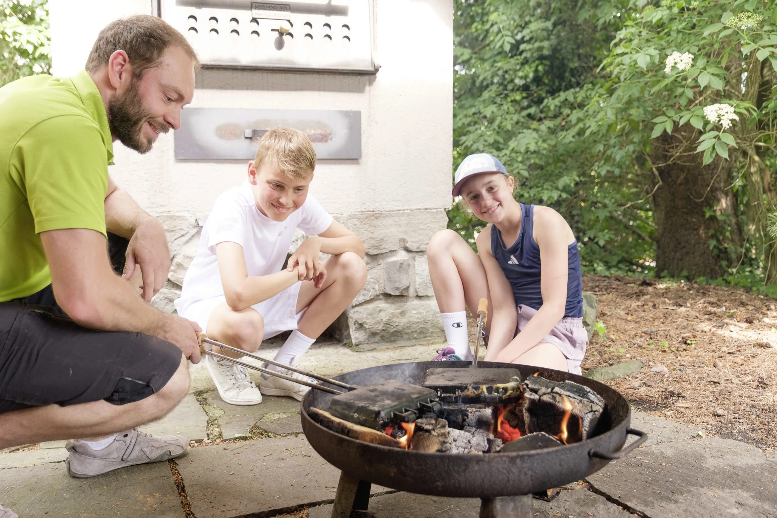 Kinder beim Lagerfeuer mit Mann im Sonnenalp Resort in Ofterschwang.