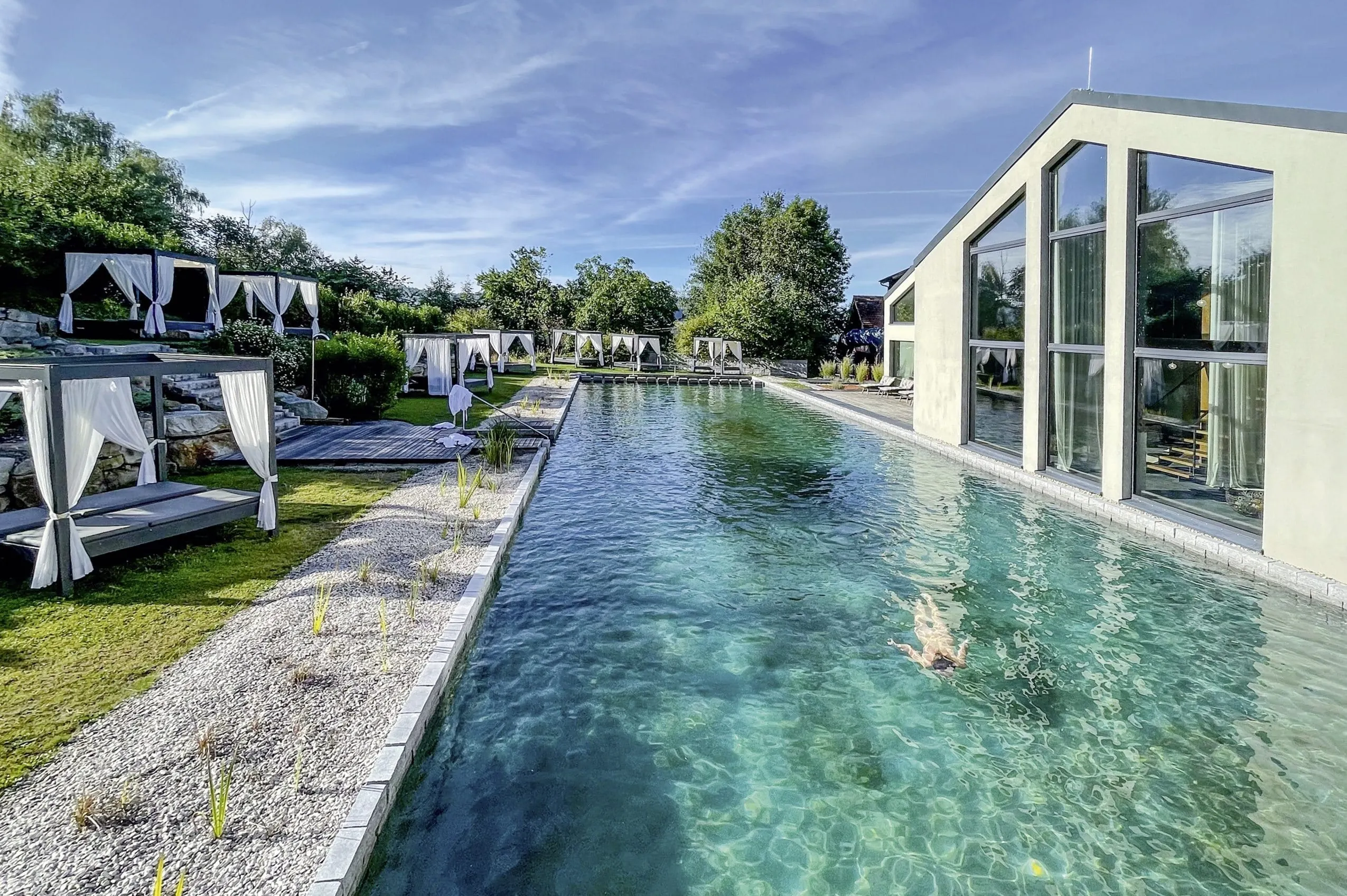 Naturpool des Ulrichshof mit gemütlichen Daybeds-Himmelbetten.