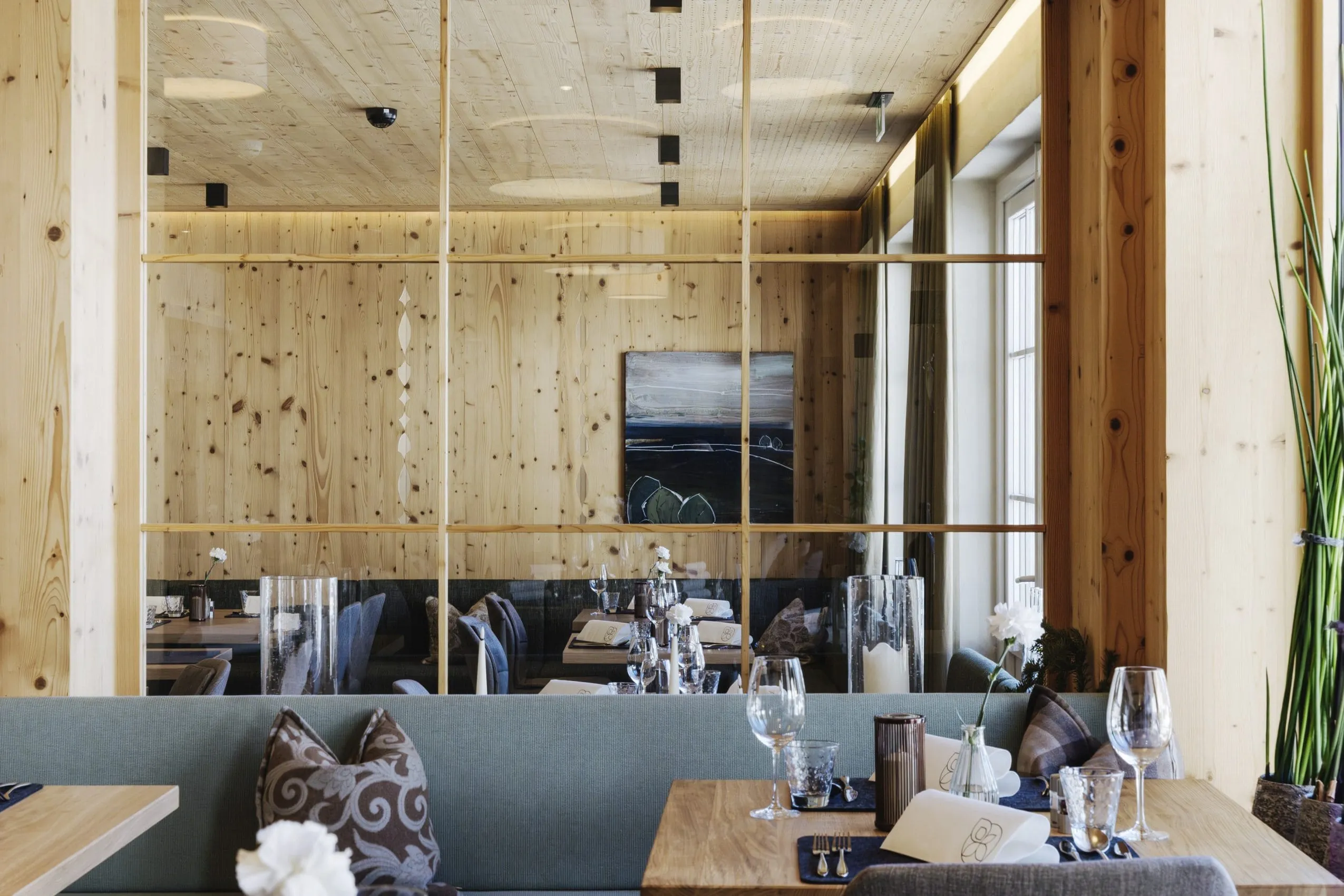 Der Restaurantbereich im Inneren des Genuss- und Aktivhotels Sonnenburg in Riezlern mit Holzfassaden.