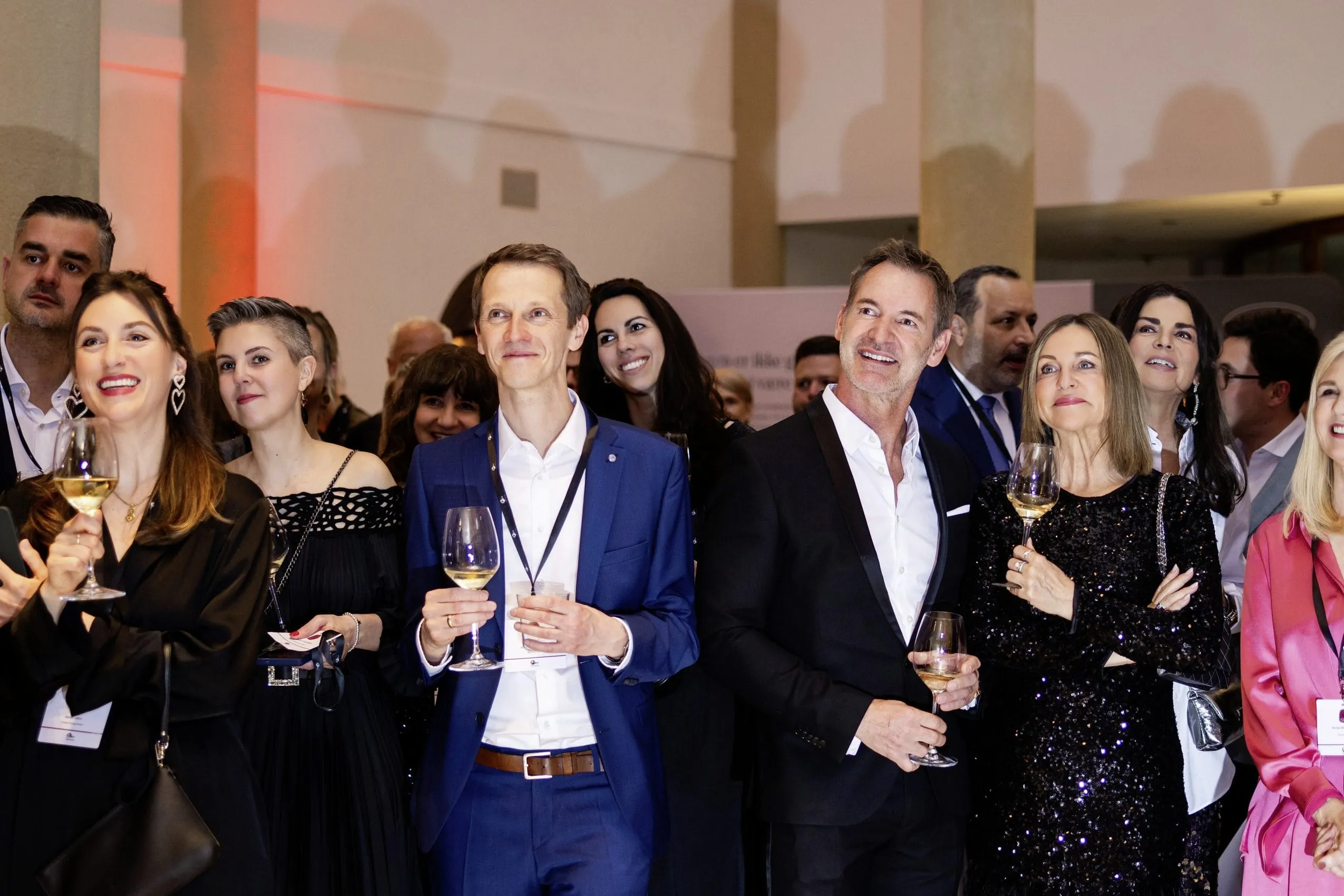 G&auml;ste in eleganter Abendkleidung bei der Wellness Aphrodite, viele mit Weingl&auml;sern in der Hand