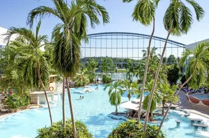 Die Südsee Therme Bad Wörishofen mit Palmen, großem Thermalbecken und Glasfassade als besonderes Erlebnis im Ringhotel Sonneck.