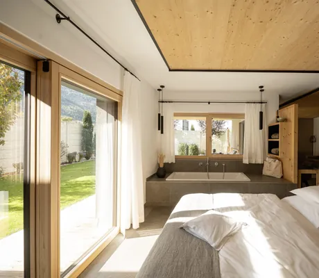 Schlafzimmer im Amolaris mit Blick ins Grüne und Badewanne