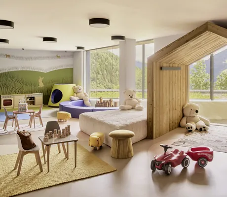 Gemütliches Babyland mit Kuscheltieren, Spielmöglichkeiten, Bobbycar und großen Fenstern mit Ausblick auf die Natur im Falkensteiner Family Hotel Montafon