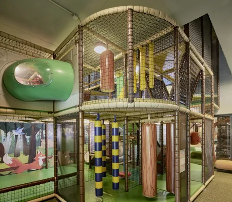 Indoor-Spielbereich Falkyland mit Klettergerüsten, Rutschen und bunten Elementen im Falkensteiner Family Hotel Montafon