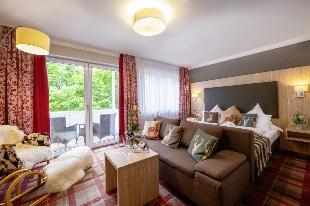 Das Allgäu Zimmer im Ringhotel Sonneck in Bad Wörishofen mit gemütlicher, brauner Couch sowie eleganter Lässigkeit.