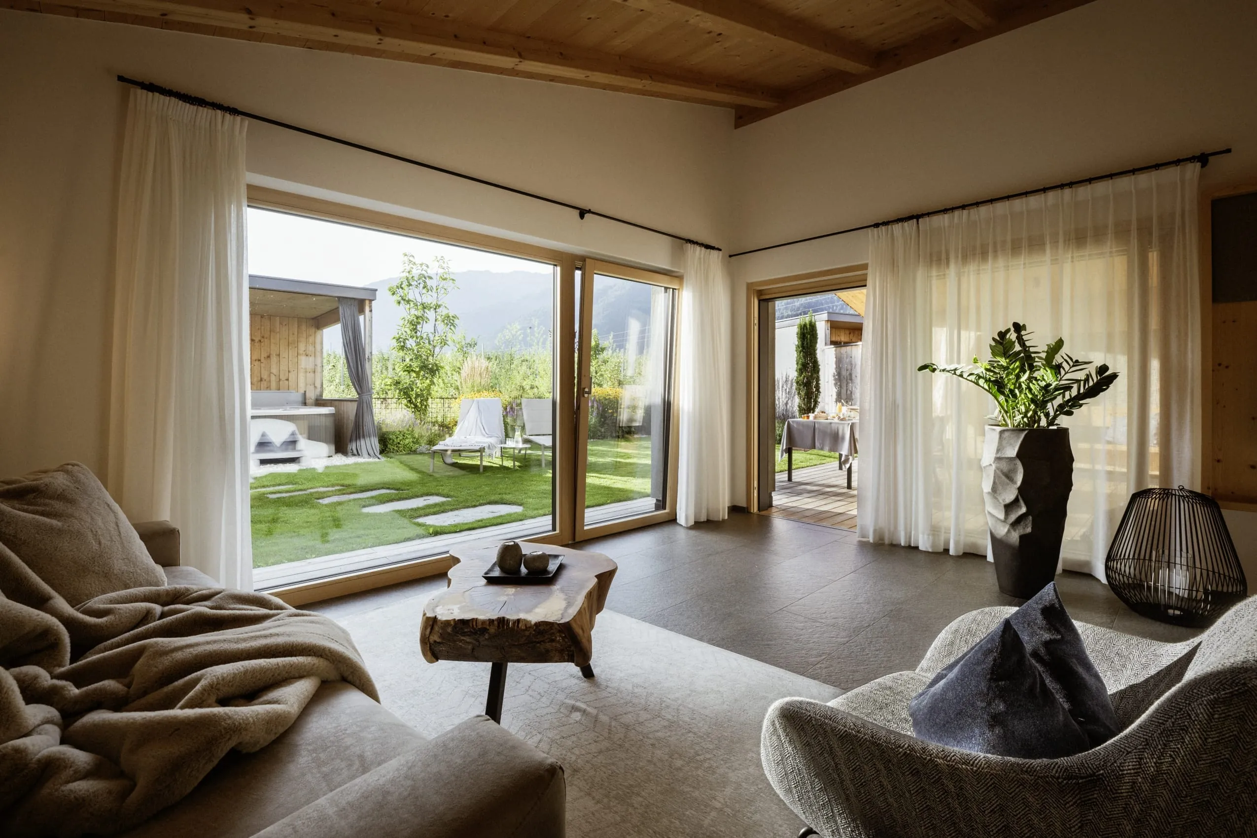 Ein Wohnbereich im Amolaris Garden Lodges & Guesthouse mit Stoffsessel, Sofa und Kuscheldecke.