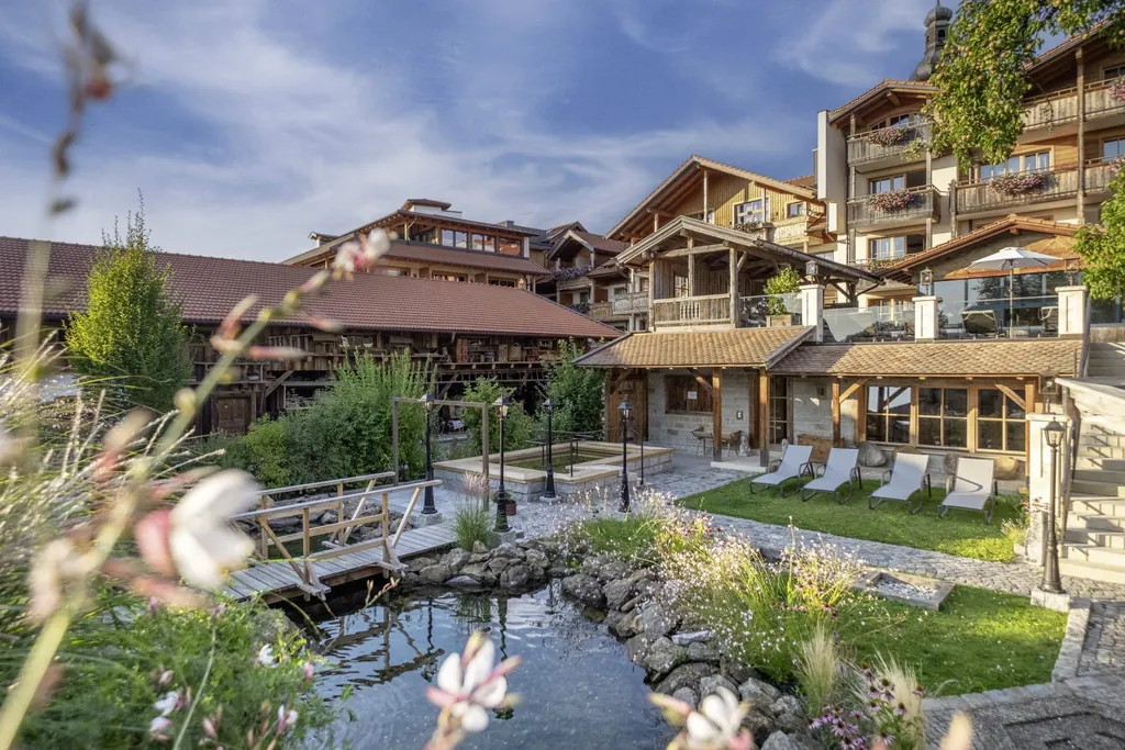 Der Au&szlig;enbereich des Natur- und Wellnesshotel Brunner Hof mit Garten und Naturteich.