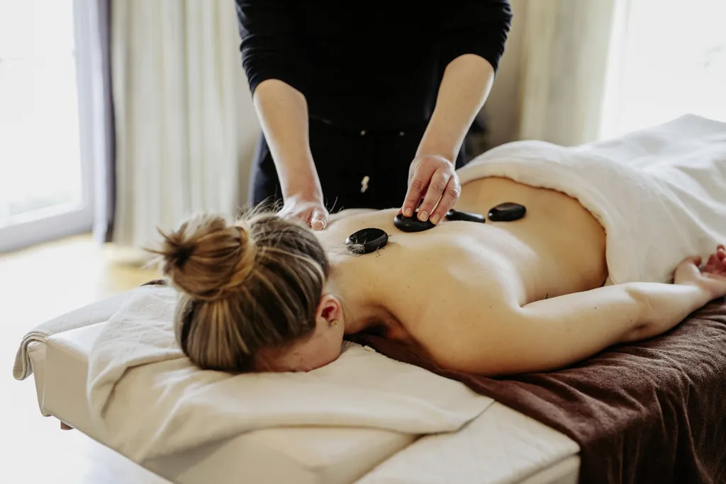Eine Frau erh&auml;lt im Wellnesshotel Randsbergerhof eine Hot Stone Massage.