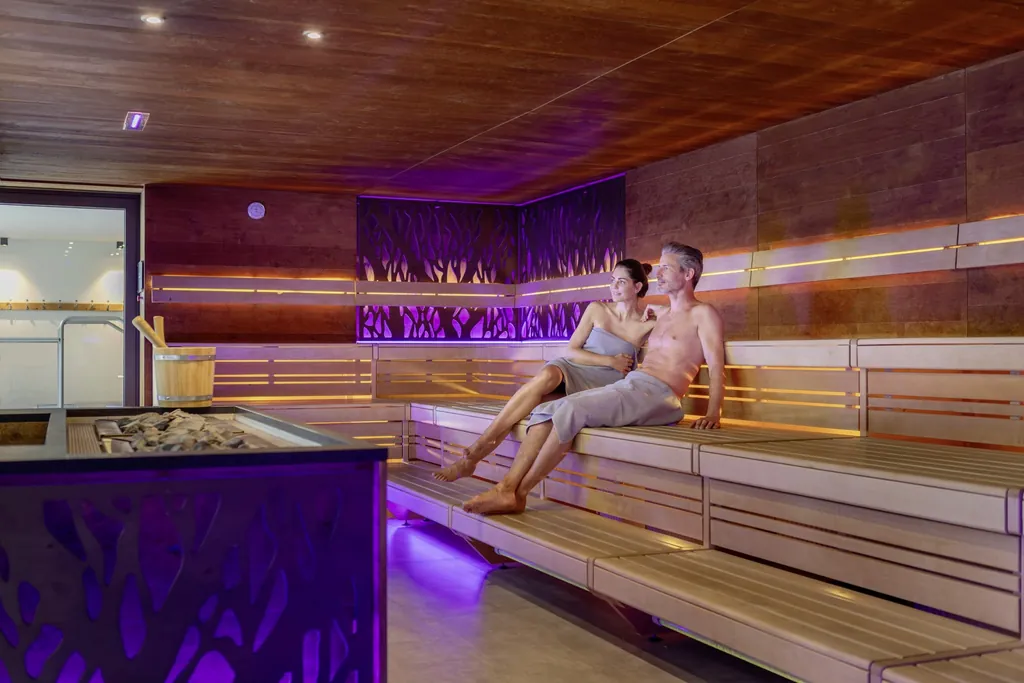 Ein Paar sitzt in der Eventsauna des Wellness- und Naturresort Reischlhof.