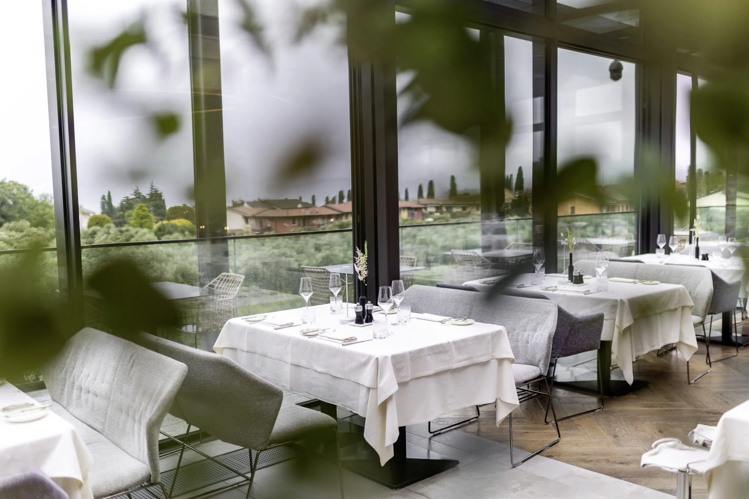 eingedeckte Tische im Quellenhof Luxury Resort Lazise mit Blick auf die H&auml;user am Ufer des Gardasees