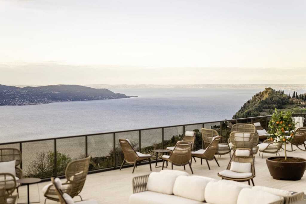Sonnenterrasse mit Lounge-Möbeln und weitem Blick auf den Gardasee und die umliegende Natur.