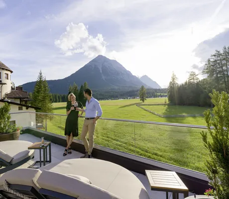 Paar prostet sich mit Rotwein auf der Dachterrasse des Alpenhotel Karwendel zu