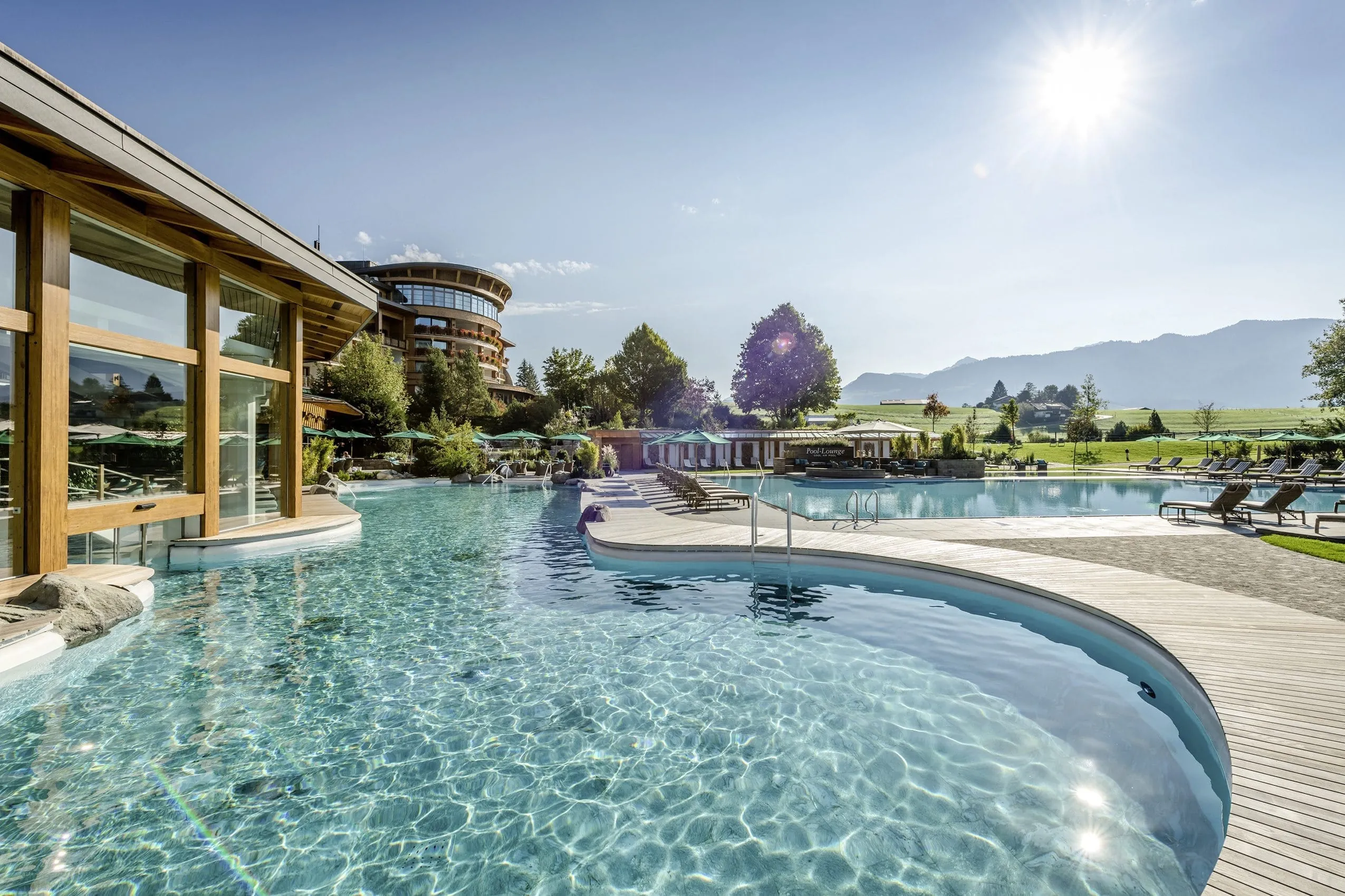 Der gro&szlig;z&uuml;gige Poolbereich des Sonnenalp Resort mit Sonnendeck und Liegest&uuml;hlen.