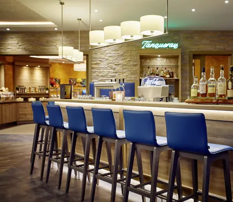 Bar in Göbels Hotel Rodenberg mit blauen Barhockern und Tanqueray Leuchtschrift