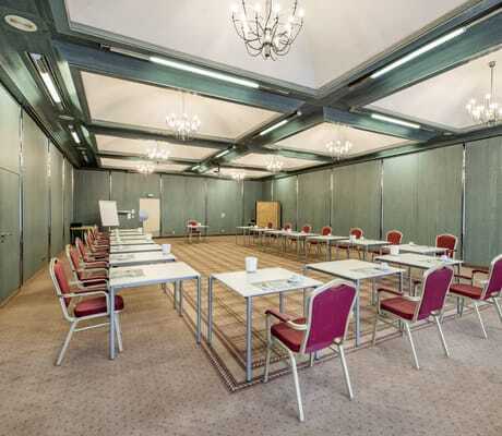 Meetingraum in Göbels Hotel Rodenberg mit grünen Balken und roten Stühlen