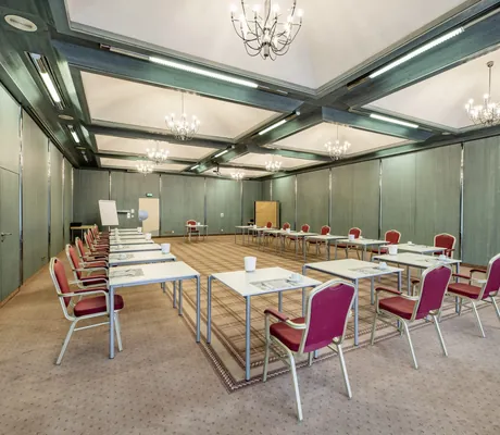 Meetingraum in Göbels Hotel Rodenberg mit grünen Balken und roten Stühlen