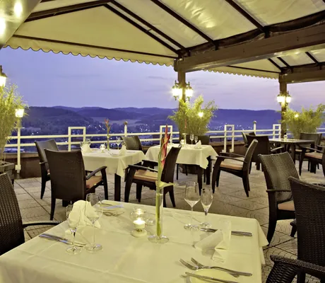 Restaurantterrasse in Göbels Hotel Rodenberg mit eindeckten Tischen und Blick in die Landschaft