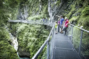 Familie steht auf Gitterbrücke über der Geisterklamm in der Nähe des Alpenhotel Karwendel