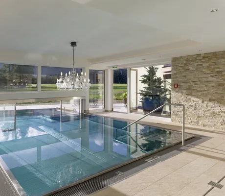 Indoorpool im Alpenhotel Karwendel mit Kristalllüster und großem Topf mit Tannenbaum