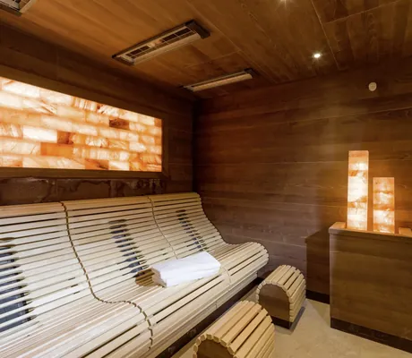 Solelounge im Alpenhotel Karwendel mit Holzliegen und zwei Salzsäulen auf dem Ofen