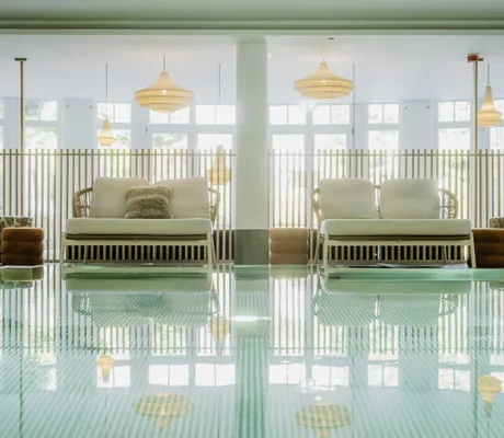 Indoorpool im Bodenmaiser Hof mit Rattanliegen und Korblampen