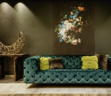 großes Cyclamfarbenes Sofa vor Blumentapete im Bodenmaiser Hof