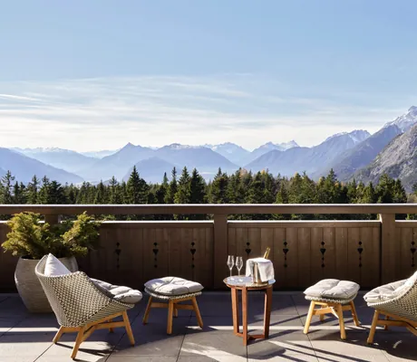 Terrasse einer Suite im Interalpen-Hotel Tyrol mit gemütlichen Sesseln, Tisch und Blick auf die malerische Berglandschaft