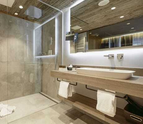 Badezimmer im Wellnesshotel Zum Bräu mit großem Waschbecken und grauen großen Fliesen