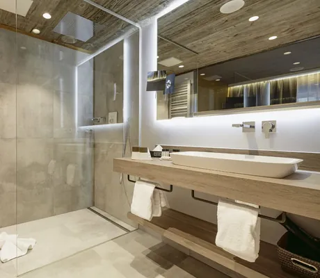 Badezimmer im Wellnesshotel Zum Bräu mit großem Waschbecken und grauen großen Fliesen