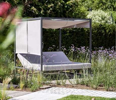 Daybed im Garten des Wellnesshotel Zum Bräu, eingebettet in Gräser und Blumen