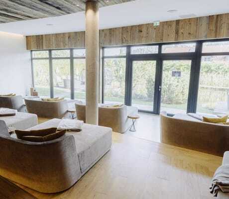 beige Doppel-Ruheliegen im Ruheraum des Wellnesshotel Zum Bräu mit Blick in den Garten