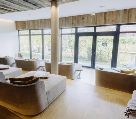 beige Doppel-Ruheliegen im Ruheraum des Wellnesshotel Zum Bräu mit Blick in den Garten