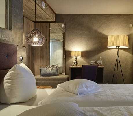 Blick vom Bett im Zimmer des Wellnesshotel Zum Bräu auf Stehleuchte und Korblampe