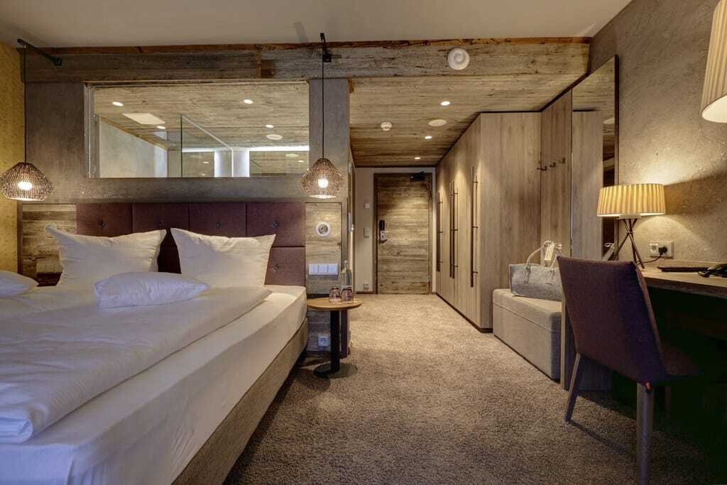Blick ins Doppelzimmer im Wellnesshotel Zum Bräu mit Fenster zum Badezimmer und Hängekorblampen