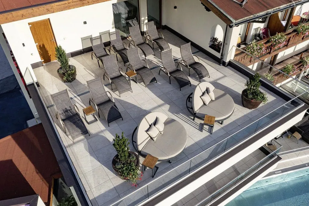 Dachterrasse im Alpenhotel Karwendel mit runden Ruheliegen und Blick auf den Außenpool