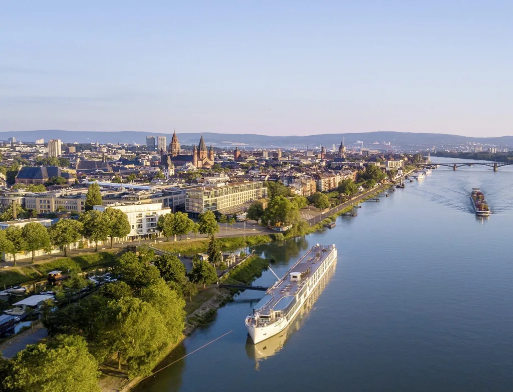 Blick auf Mainz mit Rhein, historischen Gebäuden und Schiffen im Abendlicht