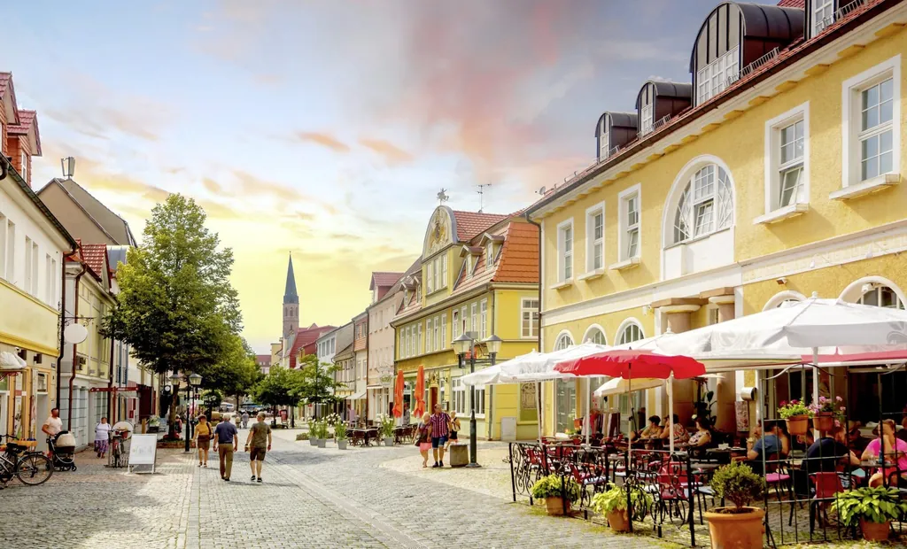 Altstadtstraße in Heilbad Heiligenstadt mit bunten Häusern, Cafés und Fußgängern unter einem farbenfrohen Abendhimmel