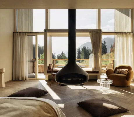 Blick über den hängenden Kamin durchs Panoramafenster der Suite im Berghotel Schlossanger Alp
