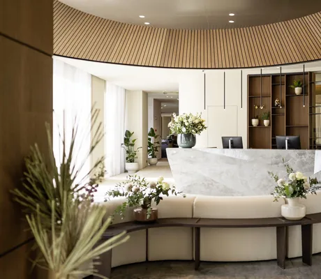 Lobby im Stroblhof Lake Garda mit Granit-Rezeption und runder beiger Couch