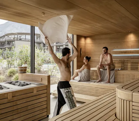 Mann schwingt Saunatuch in der Sauna des Stroblhof Lake Garda während Paar die Hitze genießt