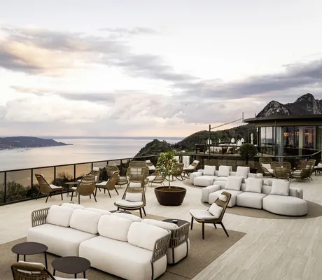 Terrasse des Stroblhof Lake Garda mit beigen Kuschelsofas und Korbsesseln mit Blick auf den Gardasee