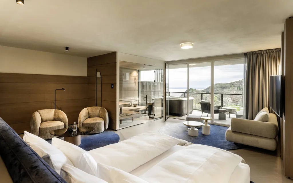Suite im Stroblhof Lake Garda mit blauen Teppichen, Whirlpool auf dem Balkon und Gardaseeblick