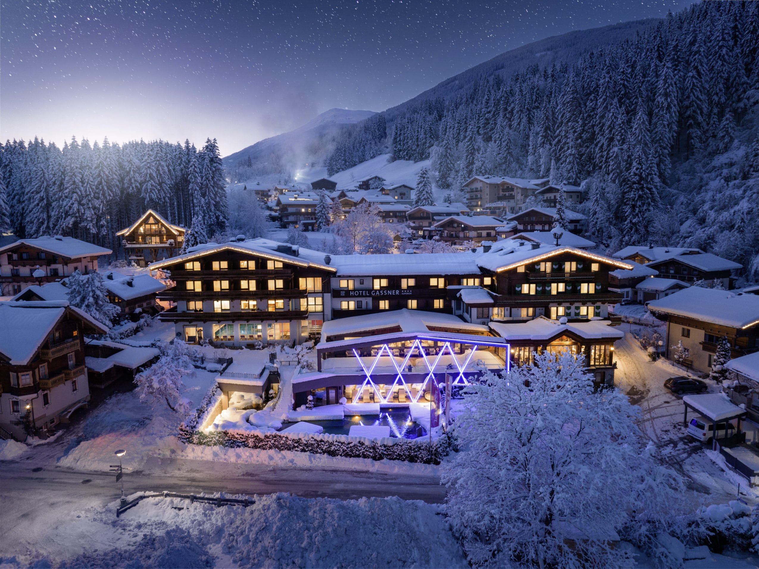 Außenaufnahme des Hotel Gassner mit beleuchteter Fassade im tiefen Schnee
