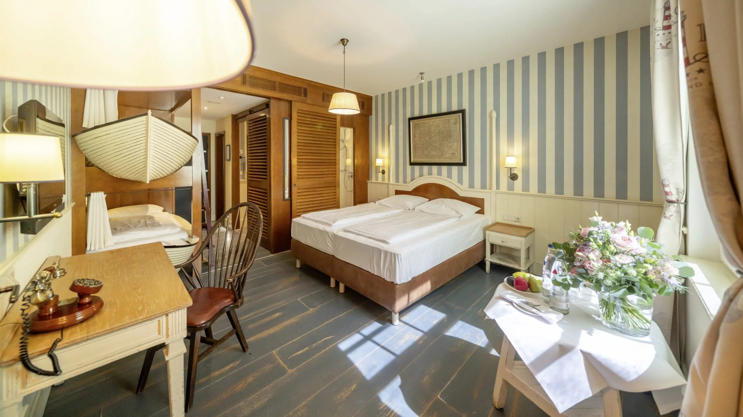 Familienzimmer im Erlebnishotel "Bell Rock" Europa-Park in Rust mit Doppelbett, Holzmöbeln, Streifenwand und Blumendekoration